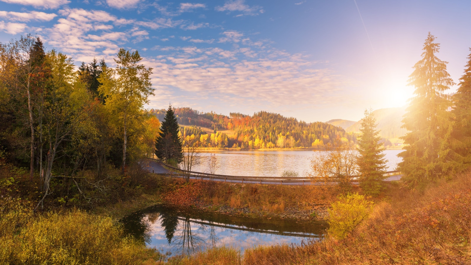 Picturesque autumn landscape with yellow trees, blue cloudy sky and reflection in the water, National park Slovak paradise, Slovakia