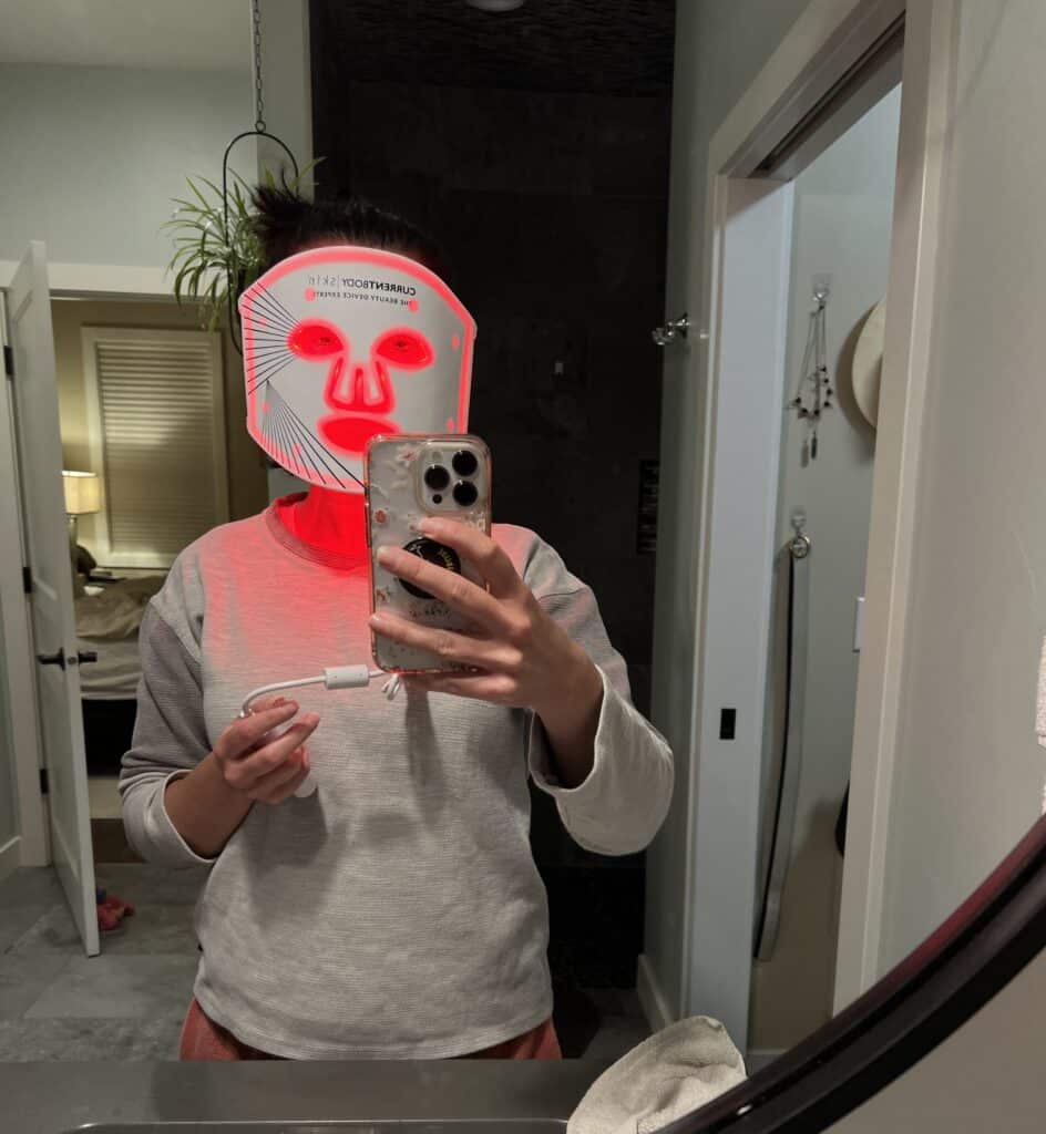 Lindsey of Have Clothes, WIll Travel wearing the CurrentBody LED Face mask in her bathroom