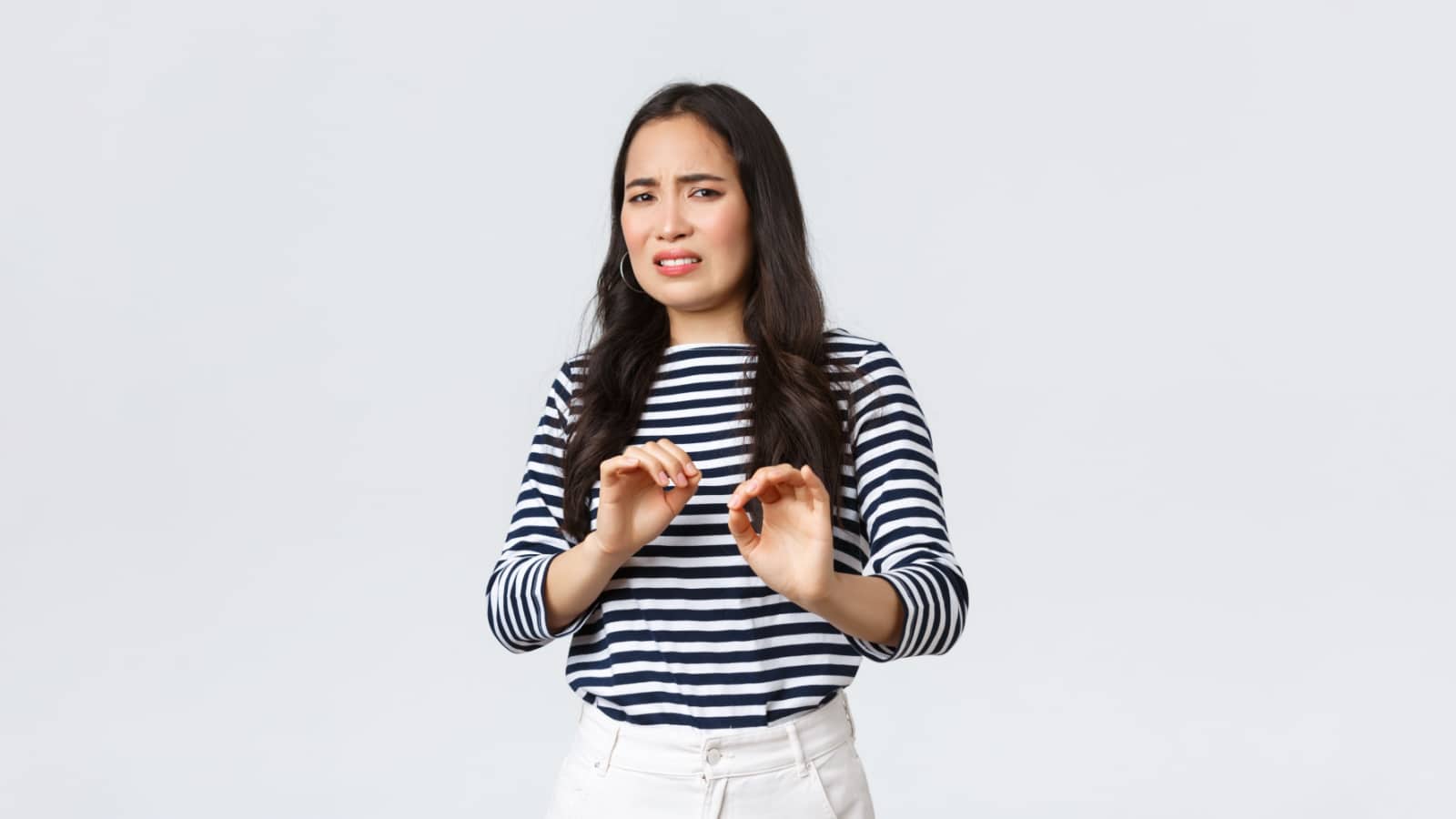 Lifestyle, beauty and fashion, people emotions concept. Reluctant and disgusted asian woman tell to stay away from her, step back and raising hands up defensive, grimacing from aversion and dislike