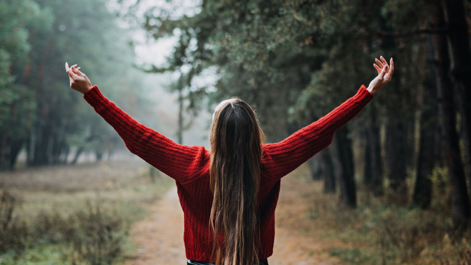 Alone Young woman with long fluttering hair express emotions in forest