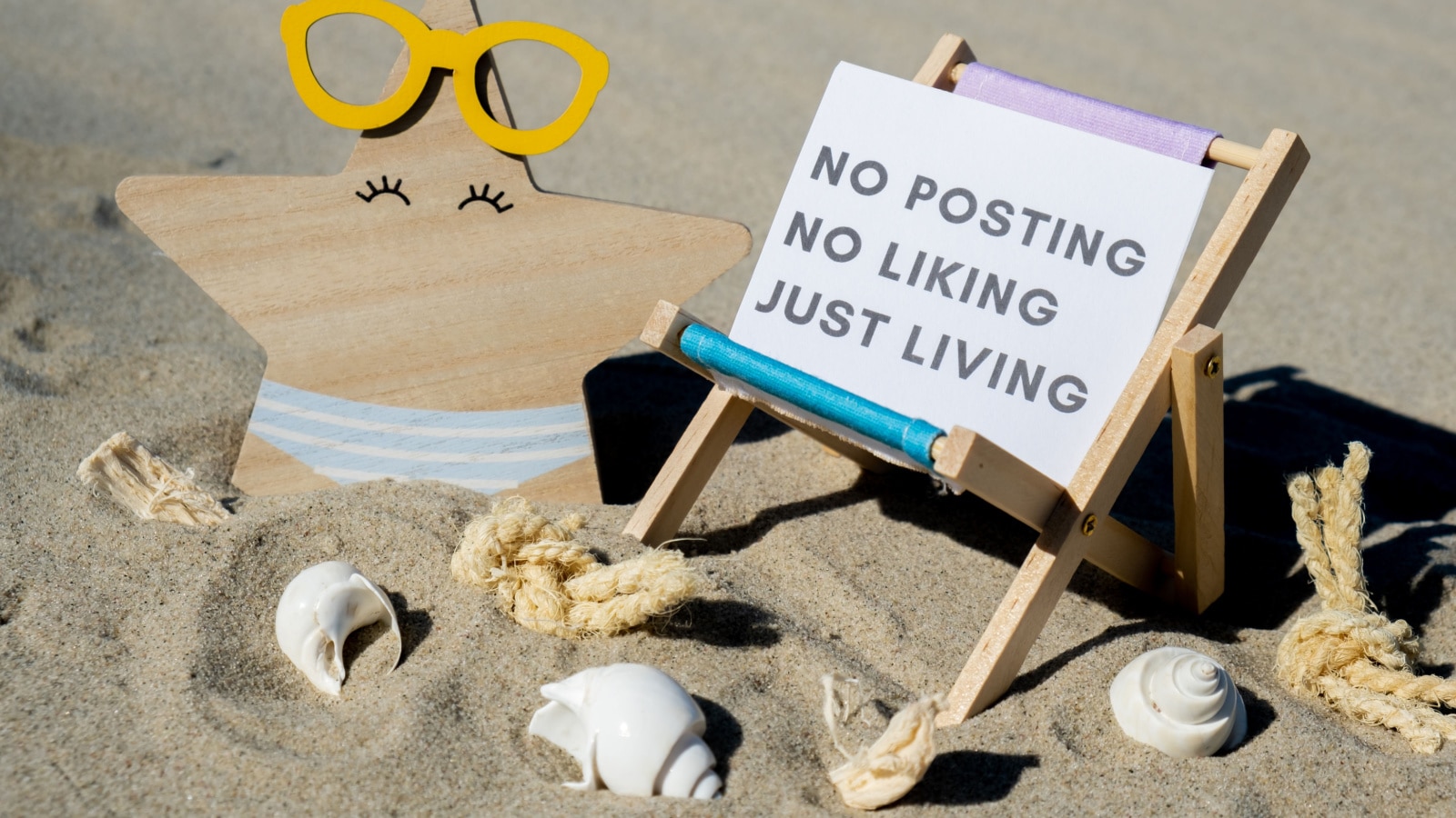 NO POSTING NO LIKING JUST LIVING text on paper greeting card on background of beach chair lounge starfish summer vacation decor. Concept of social media technology detox Sandy beach sun. Holiday