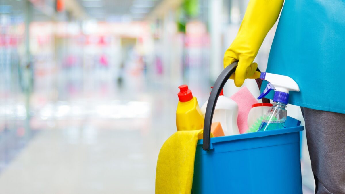 Cleaning lady with a bucket and cleaning products on blurred background.