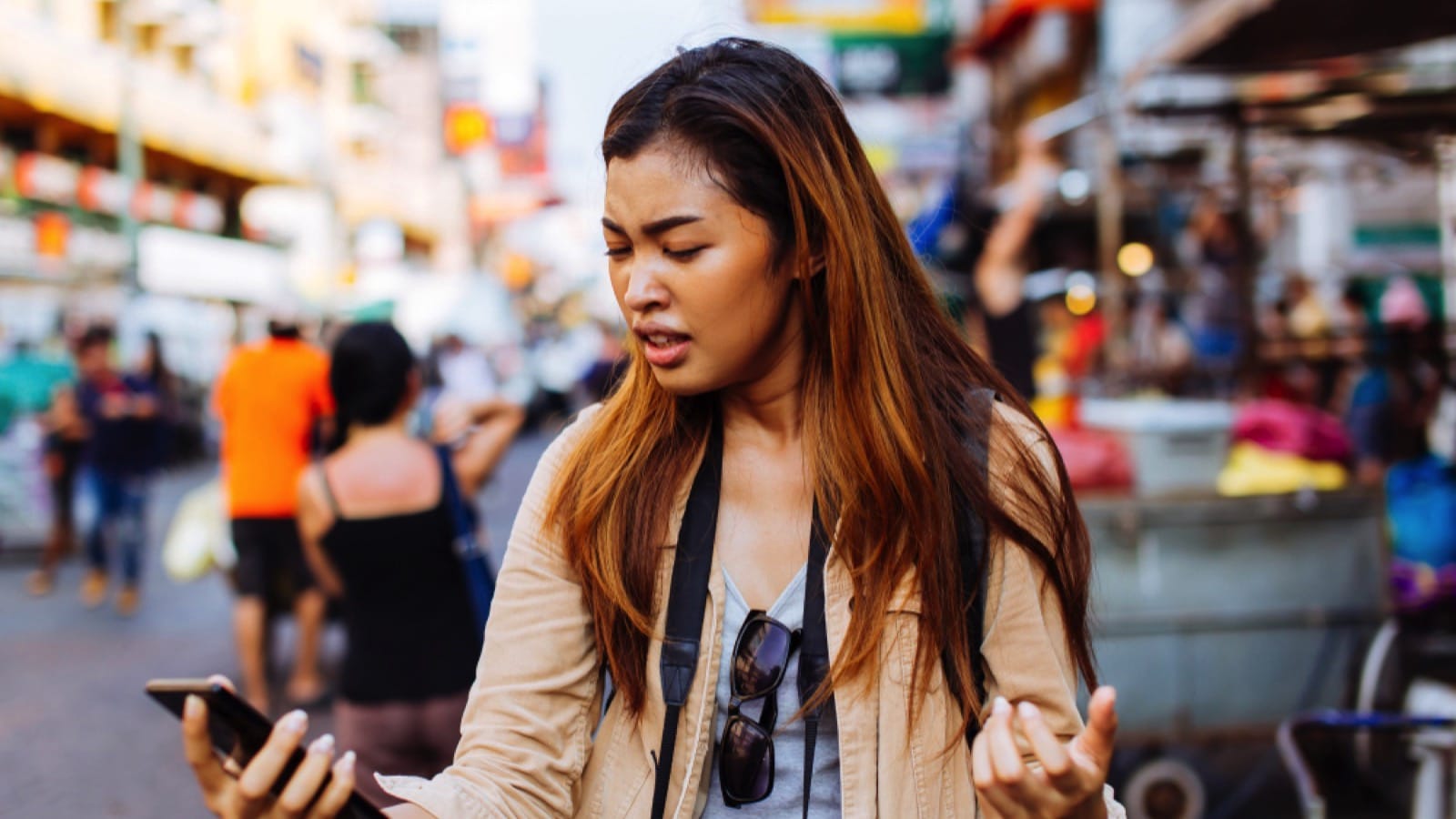 Asian woman traveler annoyed with message in mobile