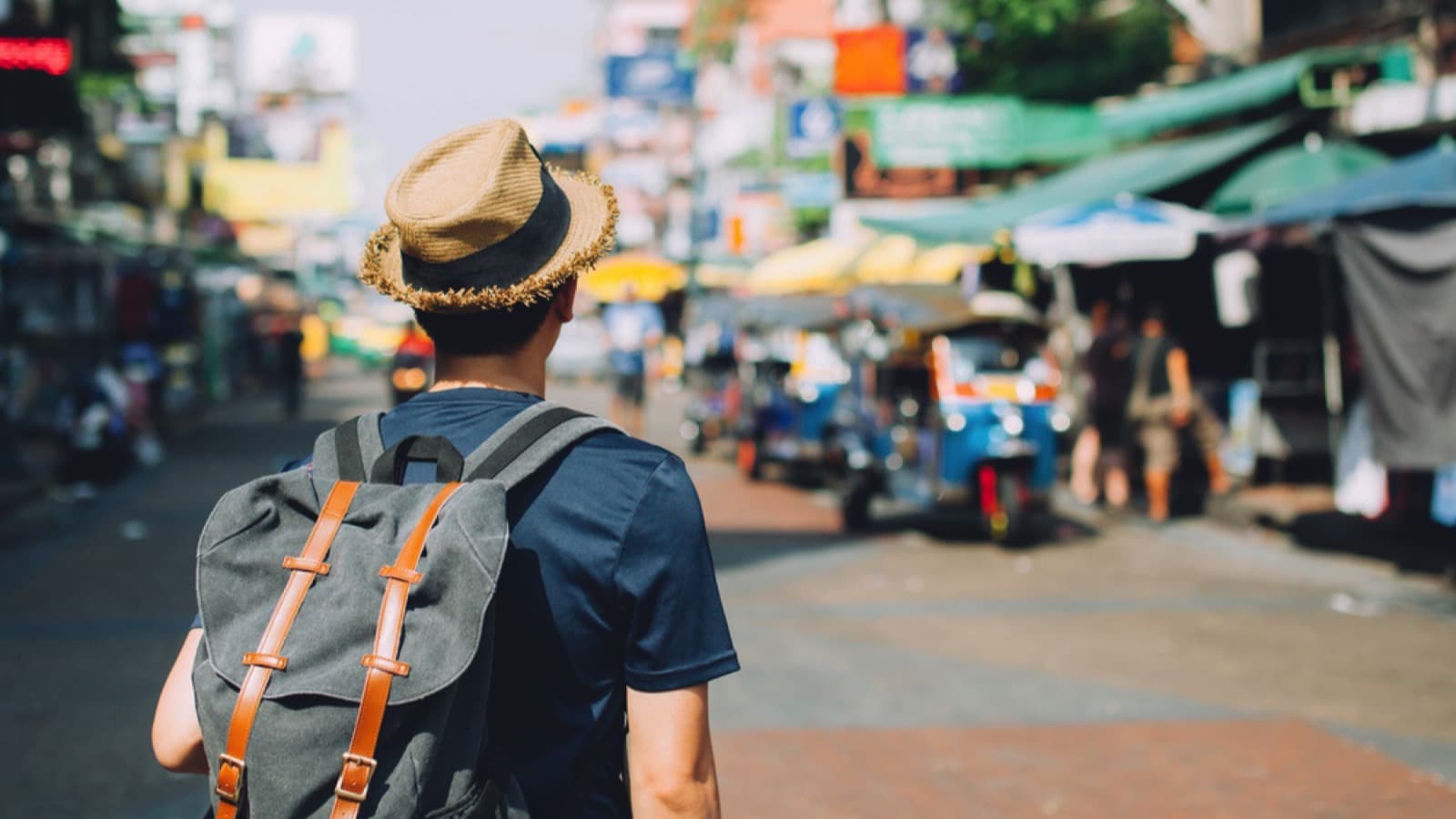 Tourist man wearing bag and walking