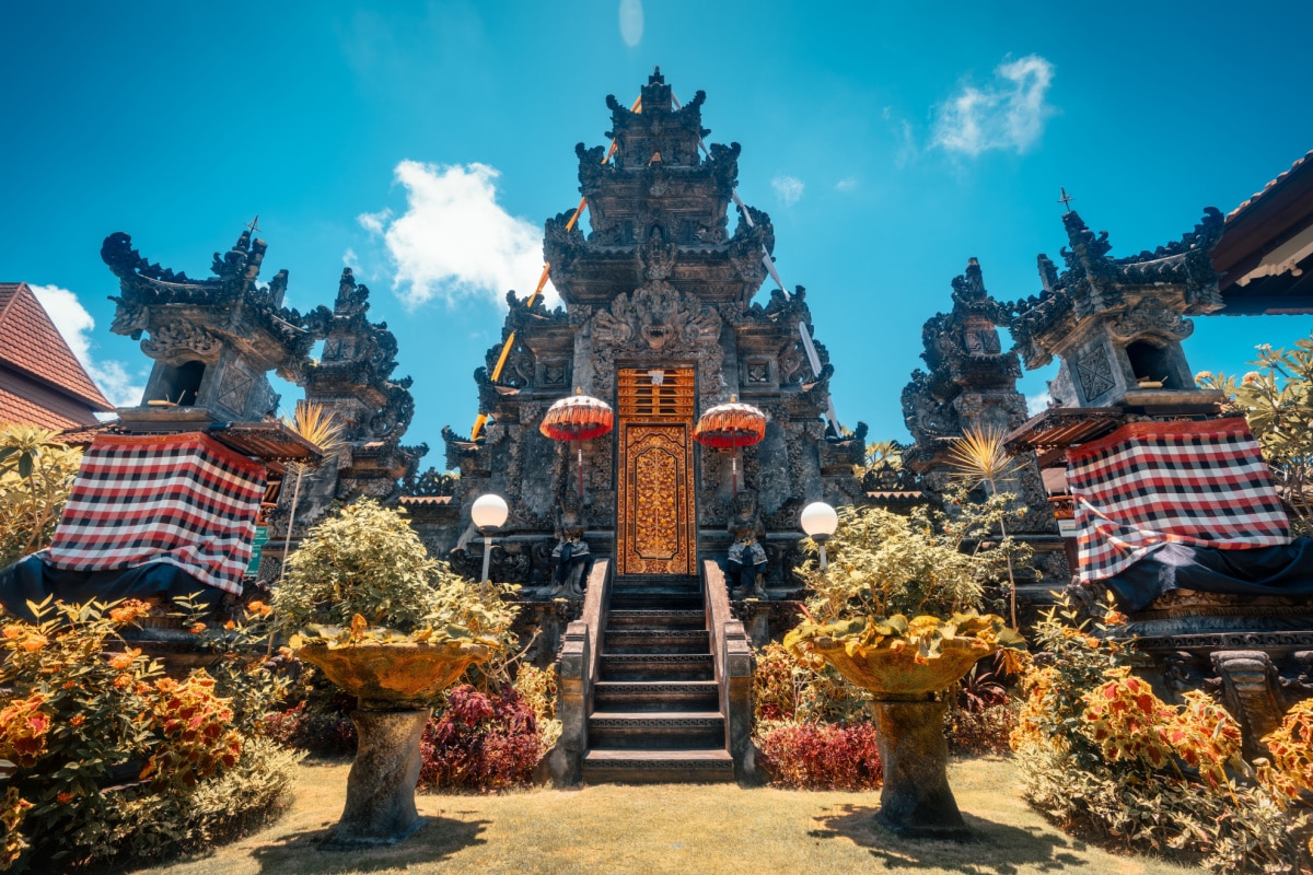 Travel people explore beautiful Bali temple with traditional Hindu symbols decorating the temple on tropical island Bali Indonesia