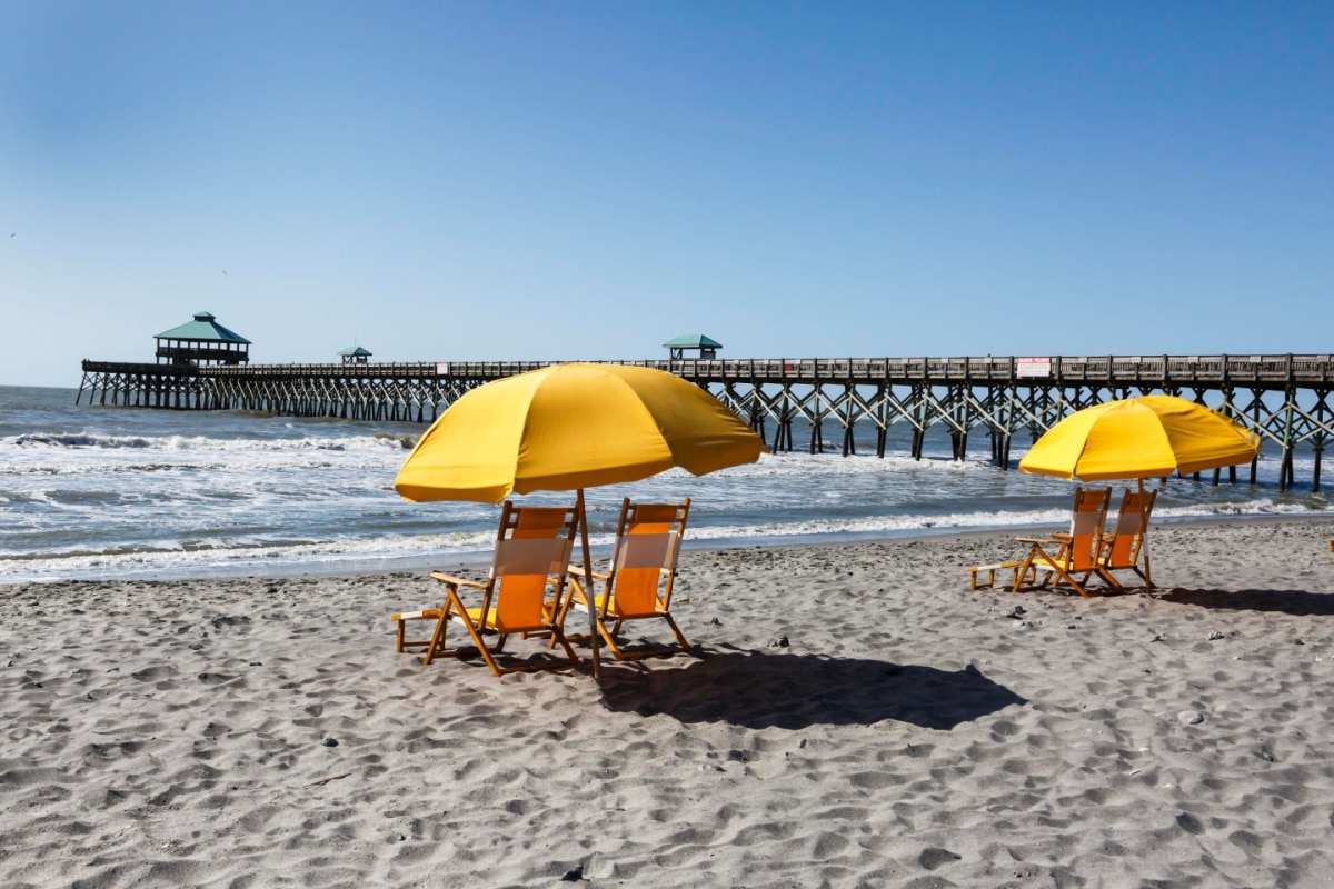 Empty beach chairs on the sand near Folly Beach pier outside Charleston, South Carolina seem to invite vacationers to come and relax.