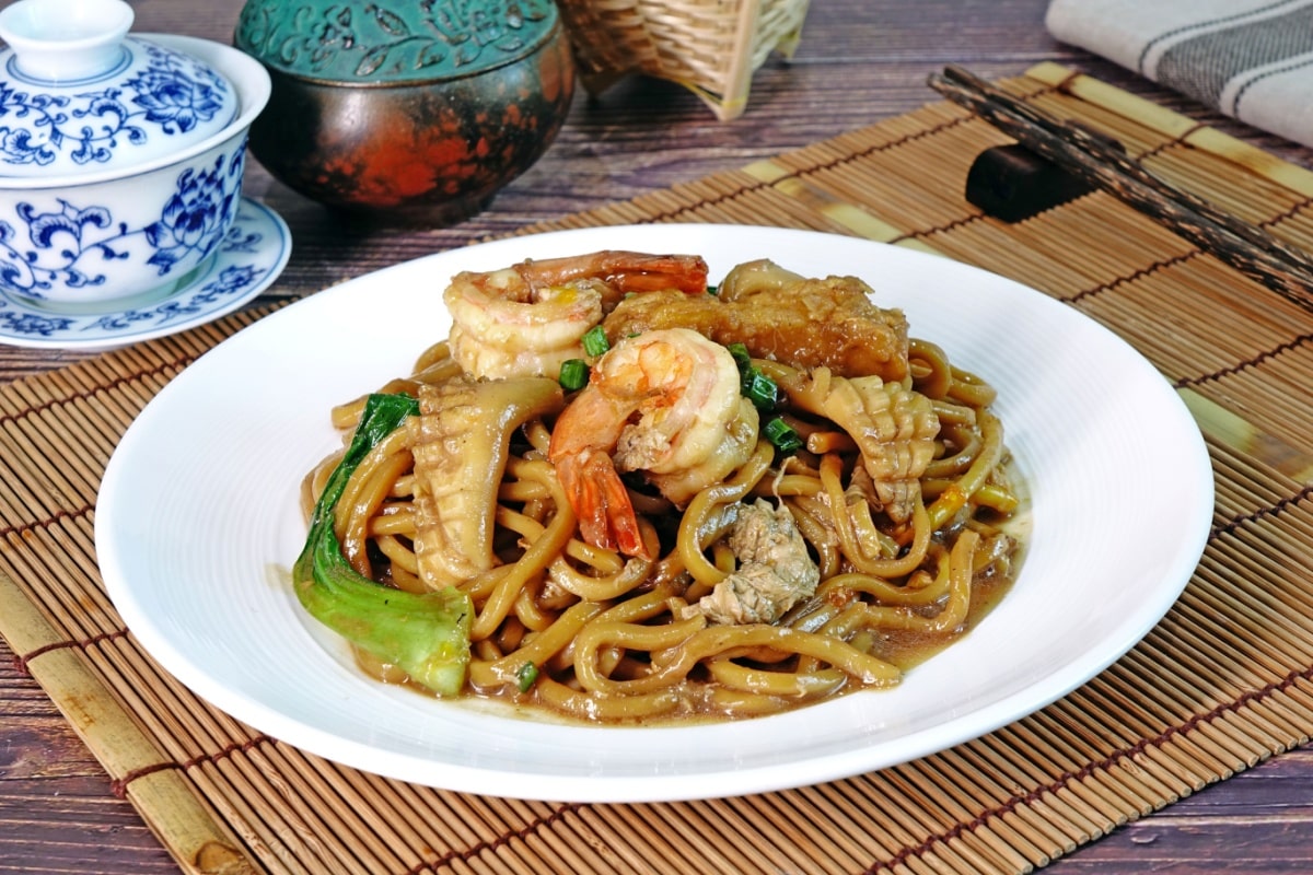 Mee Pad Hokkien or Stir-fried Hokkien Mee or Hokkien Noodles. Phuket Original Hokkien Noodles consists of thick yellow (egg) noodles fried with seafood, pork and vegetables. Selective focus