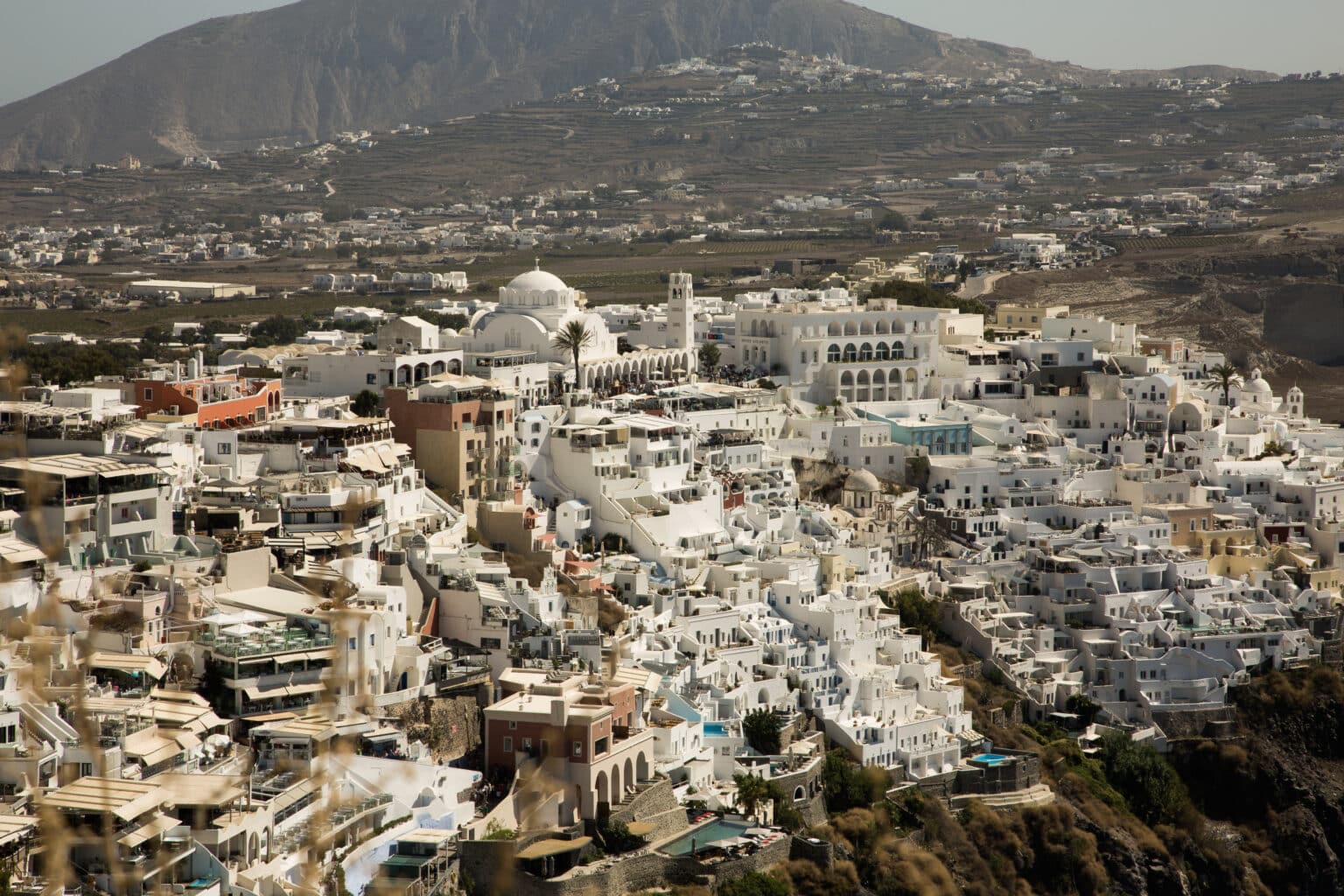 White domed building set agains a beautiful cliff in Santorini