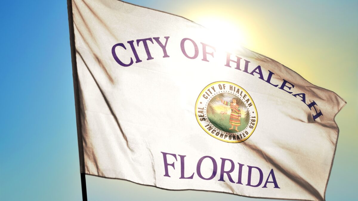 Hialeah of Florida of United States flag waving on the wind in front of sun