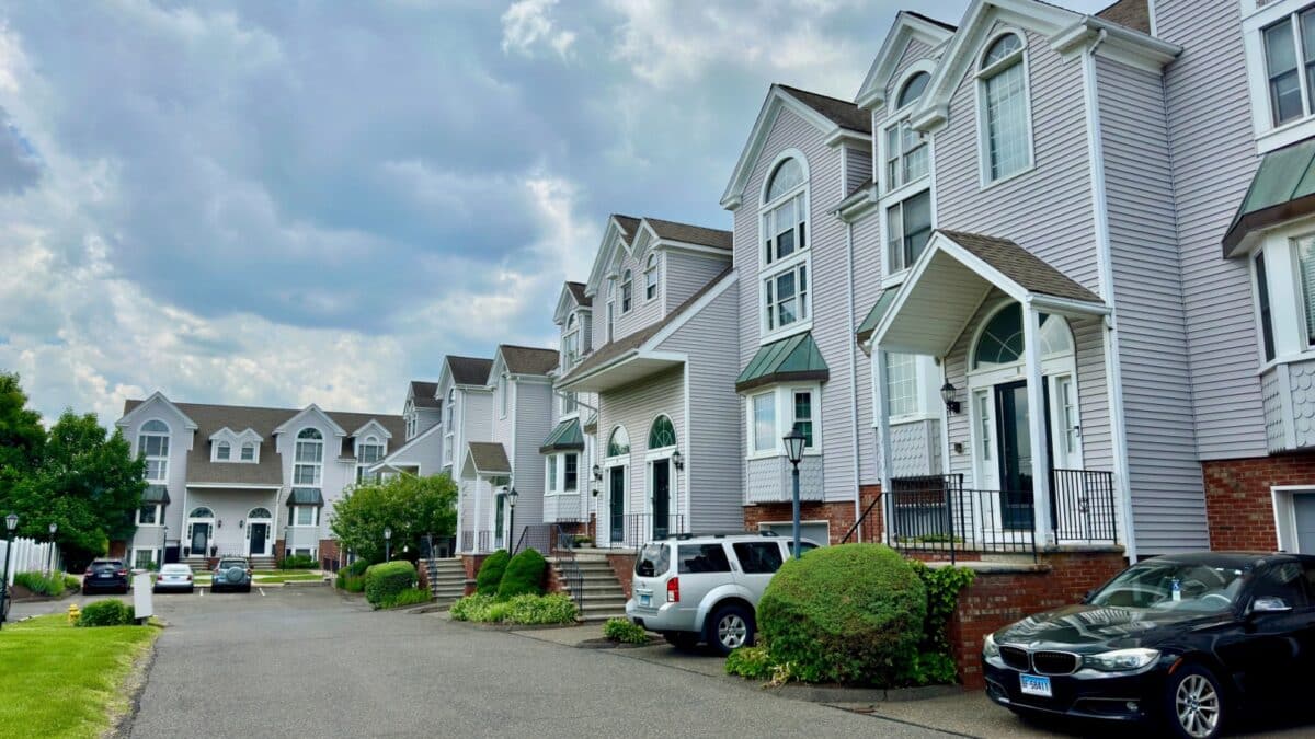 Danbury, Connecticut, USA - May 26, 2024: Two-story townhouses located in Deer Hill neighborhood. Cars parked in front of each unit.