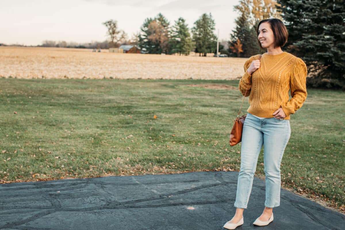 Lindsey wearing a yellow marie oliver sweater in fall