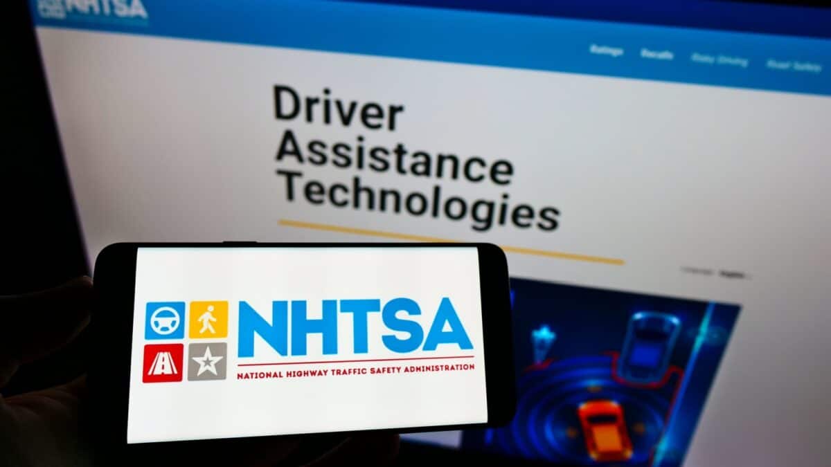 Stuttgart, Germany - 05-23-2021: Person holding cellphone with logo of National Highway Traffic Safety Administration (NHTSA) on screen in front of web page. Focus on phone display. Unmodified photo.