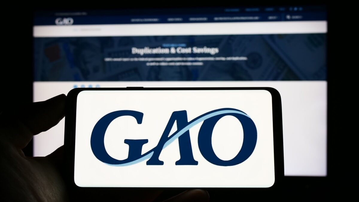 Stuttgart, Germany - 04-23-2023: Person holding cellphone with logo of US Government Accountability Office (GAO) on screen in front of webpage. Focus on phone display. Unmodified photo.