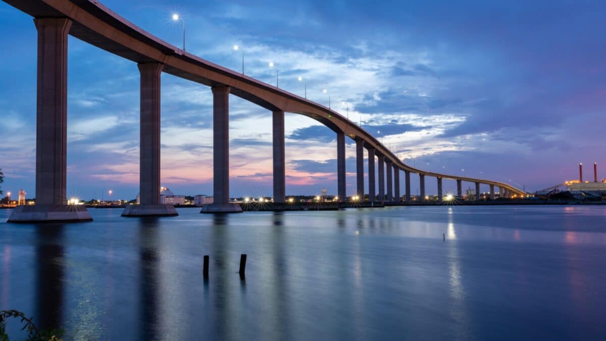 The Jordan Bridge over the Elizabeth River on the border of Norfolk and Chesapeake Virginia against a beautiful red, purple, pink, and blue sunset